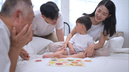 Before putting the kids to bed, parents, grandparents, and kid unwind and play in the bedroomの写真素材