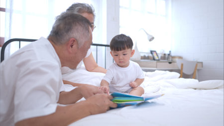 Before putting the kids to bed, grandparents, and kid unwind and play in the bedroomの写真素材