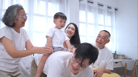 Before putting the kids to bed, parents, grandparents, and kid unwind and play in the bedroomの写真素材