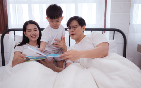 Before putting the kids to bed, parents, and kid unwind and play in the bedroomの写真素材