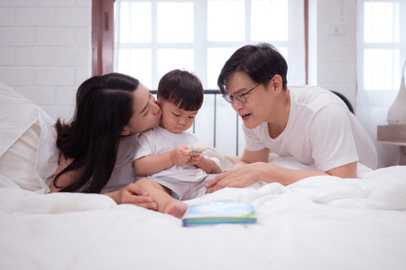 Before putting the kids to bed, parents, and kid unwind and play in the bedroomの写真素材