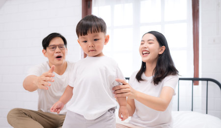 Before putting the kids to bed, parents, and kid unwind and play in the bedroomの写真素材