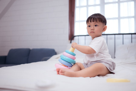 Before putting the kids to bed, kid unwind and play with toy in the bedroomの写真素材
