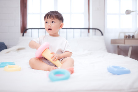 Before putting the kids to bed, kid unwind and play with toy in the bedroomの写真素材