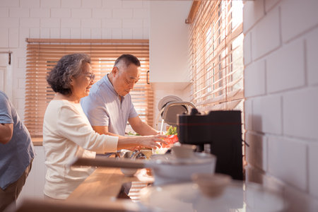 Happy Asian grandparents enjoying cooking the mealtime in the kitchenの写真素材