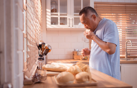 Happy Asian grandfather enjoying cooking the mealtime in the kitchenの写真素材