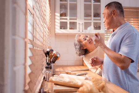 Happy Asian grandparents enjoying cooking the mealtime in the kitchenの写真素材