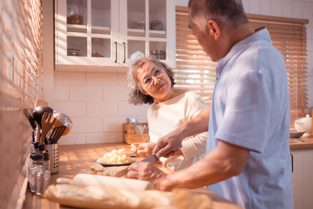 Happy Asian grandparents enjoying cooking the mealtime in the kitchenの写真素材