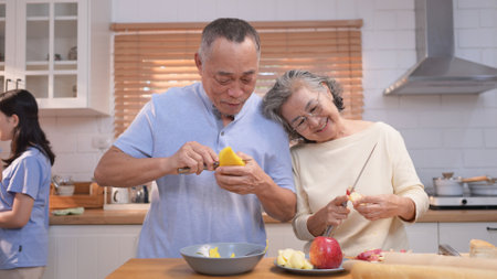 Happy Asian family preparing food together in a bright kitchen, sharing joyful moments with a toddler during a fun and healthy cooking timeの写真素材