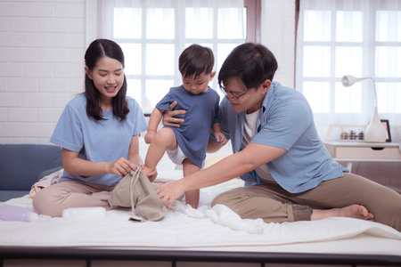 Happy time after bath, Asian kid and parents enjoying are having fun applying cream, powder and dressing upの写真素材
