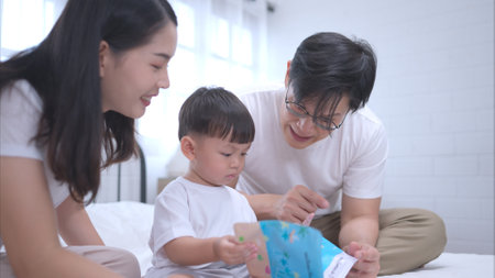 Before putting the kids to bed, parents, and kid unwind and play in the bedroomの写真素材