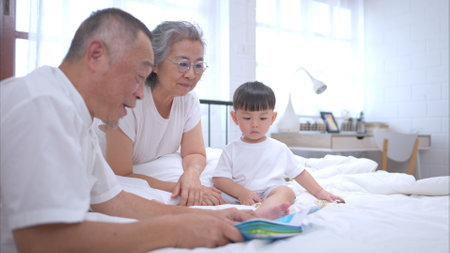 Before putting the kids to bed, grandparents, and kid unwind and play in the bedroomの写真素材