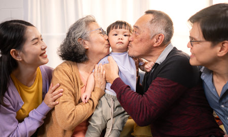 Happy multi-generational Asian family enjoying quality time together at home, cheering and smiling...