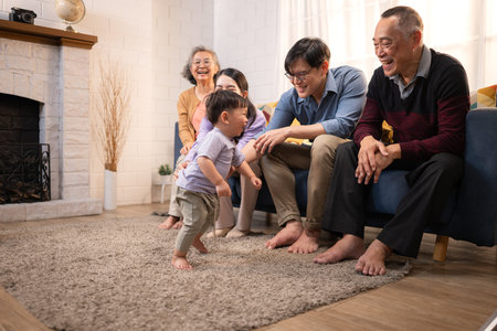Happy multi-generational Asian family enjoying quality time together at home, cheering and smiling...