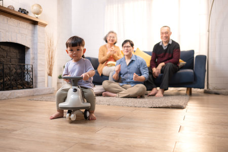 Happy multi-generational Asian family enjoying quality time together at home, cheering and smiling...