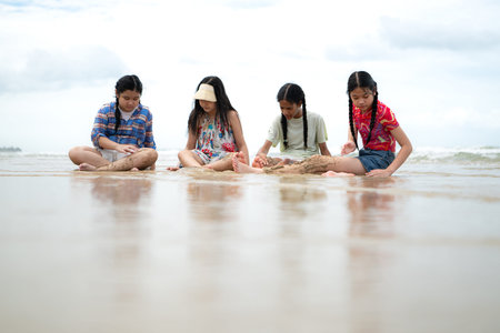Happy children playing together in the sea, enjoying a fun summer day at the beach with laughter and...