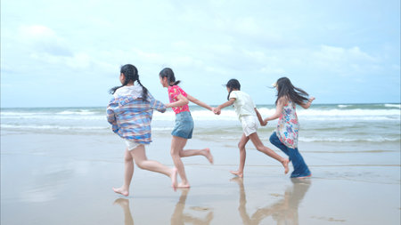 Happy children playing together in the sea, enjoying a fun summer day at the beach with laughter and...