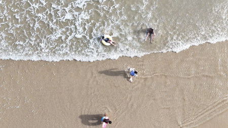 Happy children playing together in the sea, enjoying a fun summer day at the beach with laughter and...