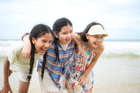 Happy children playing together in the sea, enjoying a fun summer day at the beach with laughter and...