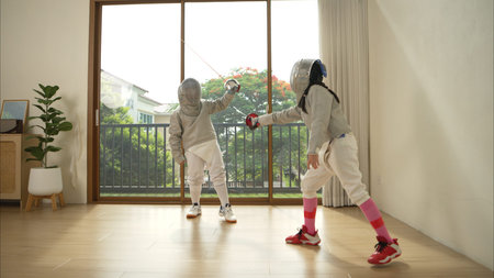 Before the tournament day, a boy and girl dressed in fencing gear are rehearsing in gym
