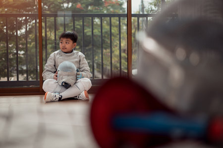 Before the tournament day, a boy dressed in fencing gear are rehearsing in gym