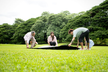 Happy multi generational Asian family enjoying picnic in the park, Creating joyful outdoor lifestyle...