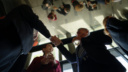 Business professionals networking and enjoying drinks at a corporate event in a modern office...