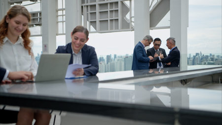 Business team working together on a laptop during an outdoor meeting on a modern rooftop