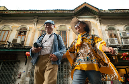 Happy senior couple walking on a city street, holding hands and sightseeing together, enjoying travel and urban lifestyleの写真素材