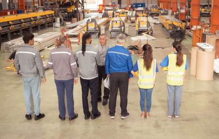 Group of Industrial worker inspecting inside a large metal tube in a factory wearing safety helmet