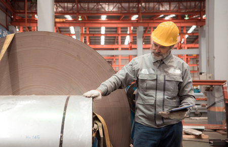 Senior experienced technician checking large machine on a production line at an industrial factoryの写真素材