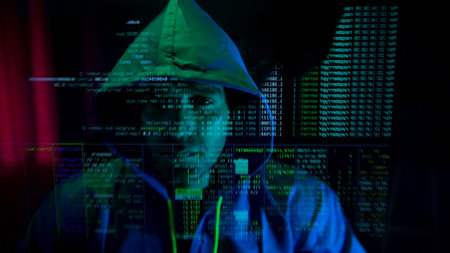 Anonymous hacker wearing a mask and hoodie interacting with digital data in a dark room,...