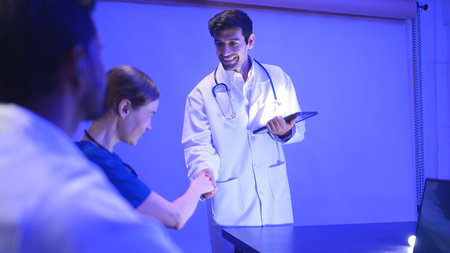 Doctors and medical professionals discussing heart health with futuristic hologram technology in a...