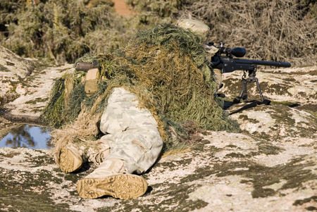 Sniper with ghillie waiting for target in an Airsoft partyの写真素材