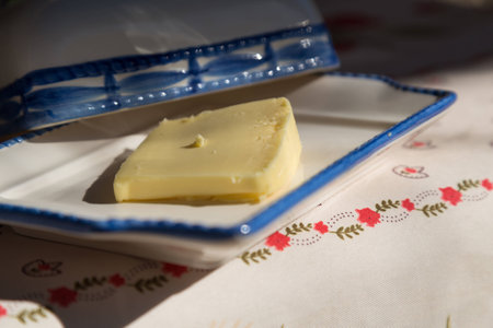 Fresh Butter on Plate with Table Cloth in Backgroundの写真素材