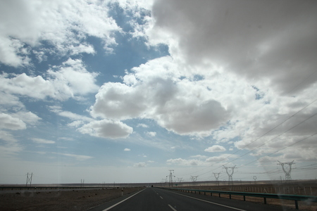 Long road with transmission towers by the sideの写真素材
