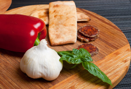 Garlic, red pepper, basil leaf, salami and breadの写真素材