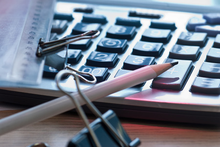 Office calculator and ruler lying on the desk in the officeの写真素材