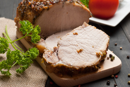 Slow roasted pork loin lying on wooden tableの写真素材