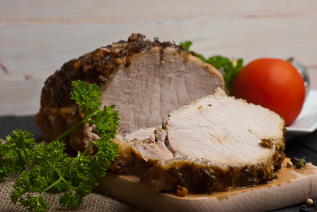 Slow roasted pork loin lying on wooden tableの写真素材