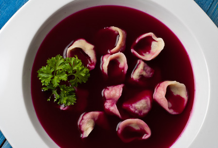 Traditional polish clear red borscht with dumplings with mushroomsの写真素材