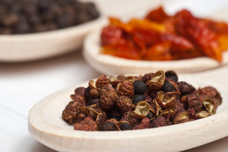 Spices. Sichuan pepper in wooden spoon - shallow depth of field