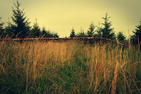 Red and white barrier blocking way to the forest - vintage effectの写真素材
