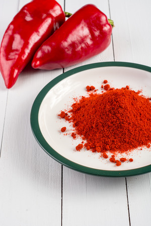 Powdered and fresh red paprika on wooden tableの写真素材