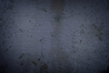 Dark grey grunge textured slate wall close up for background