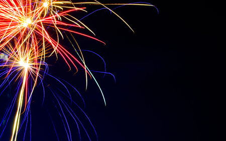 Close up of colorful fireworks against dark night sky - copy space