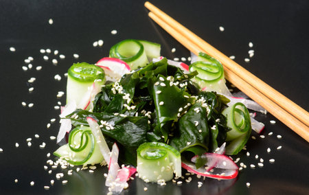 Fresh healthy vegetarian seaweed wakame salad with cucumber and red radishの写真素材