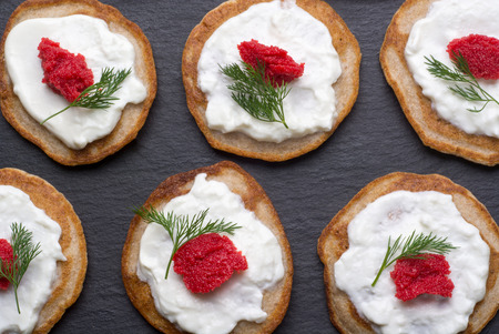 Traditional russian homemade blinis with sour cream and red caviar. Top viewの写真素材