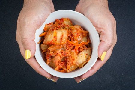 Kimchi - Korean superfood. Pickled chinese cabbage in bowl on slate plateの写真素材