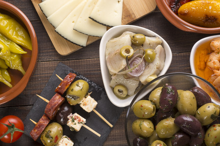 Sharing mixed spanish tapas starters on table. Top viewの写真素材